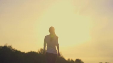 Woman walking away on summer meadow
