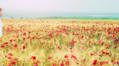 Woman running through poppies field