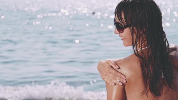 Сонцезахисна молода жінка наносить сонцезахисний крем — стокове відео