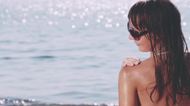 Sonnenbadende junge Frau mit Sonnencreme — Stockvideo