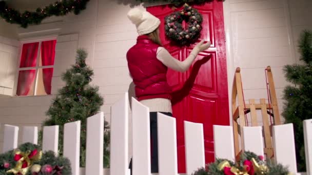 Mujer joven está decorando la puerta principal — Vídeo de stock