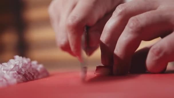 Повар режет лук ножом — стоковое видео