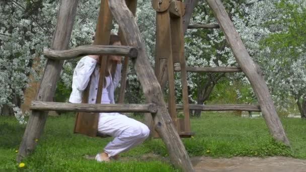 Young cheerful woman on swings — Stock Video