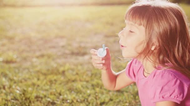 Little girl blowing soap bubbles — Stock Video