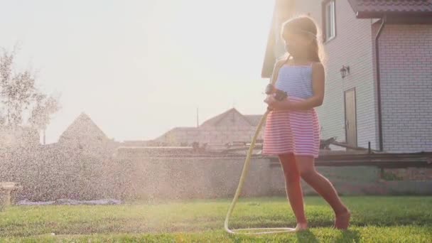 Niña regando hierba verde — Vídeo de stock