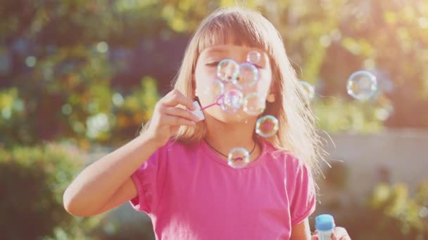 Little girl blowing soap bubbles — Stock Video