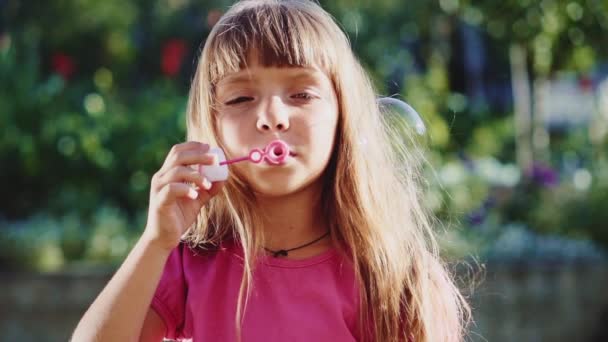 Malá holka foukání mýdlové bubliny — Stock video