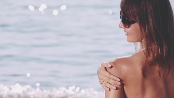 Frau trägt Sonnencreme auf ihre Schulter auf — Stockvideo