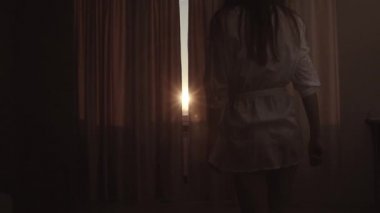 Kadın ince gövdeli perdeleri açar