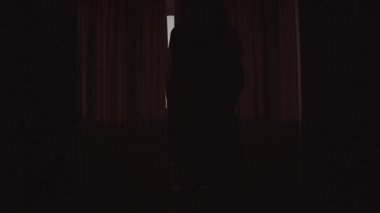 Kadın ince gövdeli perdeleri açar