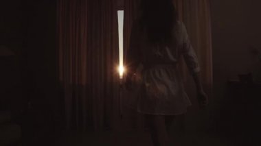 Kadın ince gövdeli perdeleri açar