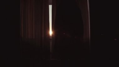 Kadın ince gövdeli perdeleri açar