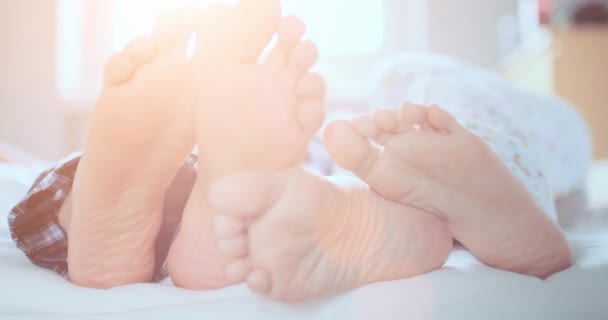 Par fötter spela footsie i sängen — Stockvideo