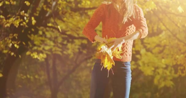 Femme heureuse jetant des feuilles 