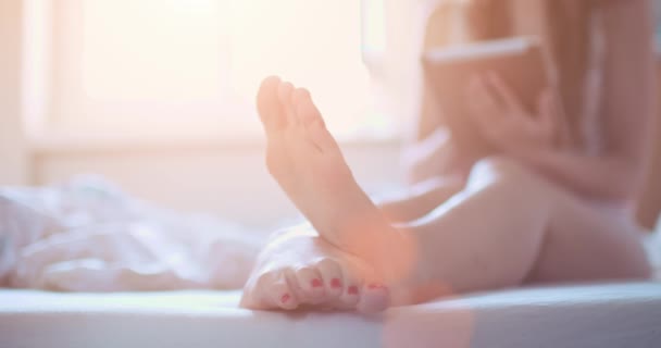 Mãos femininas com tablet digital na cama — Vídeo de Stock