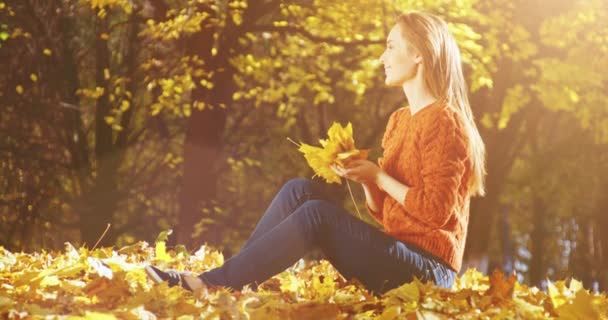 Femme heureuse jetant des feuilles 