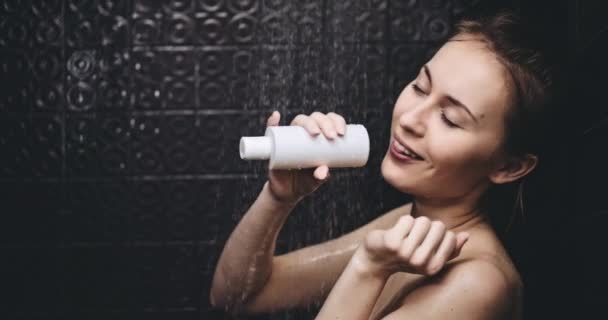 Vrouw zingt in shampoo fles — Stockvideo