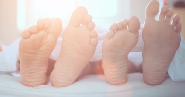 Par de pés jogando footsie na cama — Vídeo de Stock