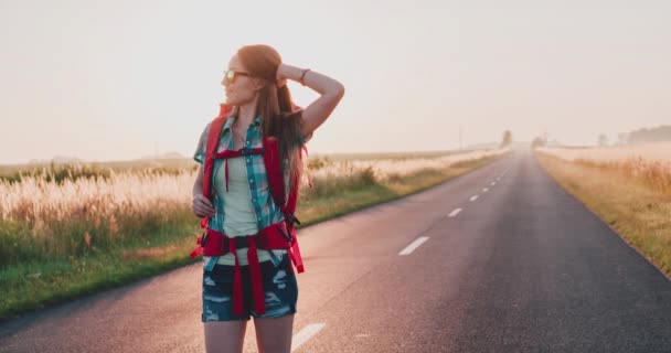 Mujer viajera caminando por un camino soleado — Vídeo de stock