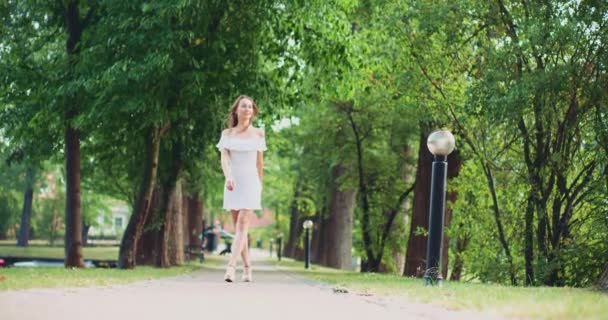 Femme marchant sur la route du parc — Video