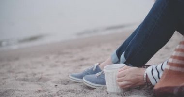 Göl kenarında sıcak kahve içen kadın.