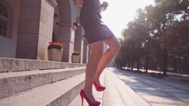 Сексуальная деловая женщина спускается по лестнице — стоковое видео