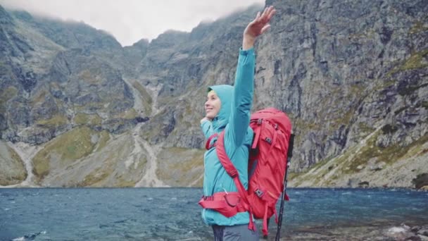 Wanderin steht mit erhobenen Händen — Stockvideo