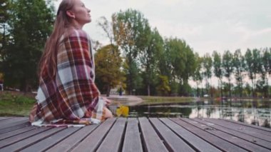 ahşap iskele üzerinde oturan kadın