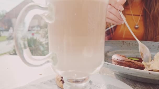 Mujer comiendo pastel de chocolate en la cafetería — Vídeos de Stock