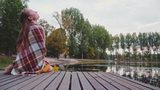 木製の桟橋に座っている女性 — ストック動画
