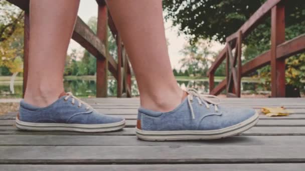 Feet of beautiful young woman on bridge — Stock Video