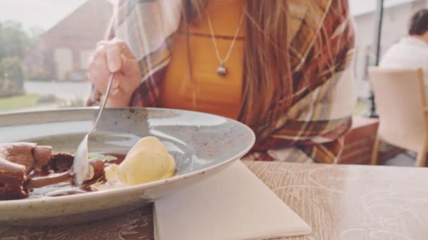 Frau isst Schokoladenkuchen im Café — Stockvideo