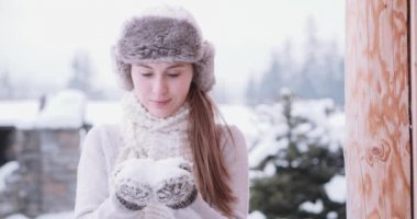 Ellerinden kar üfleyen bir kadın