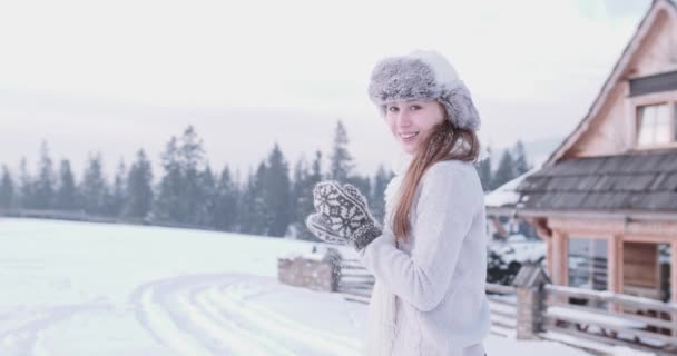 Fröhliche junge Frau, die Schnee wirft — Stockvideo