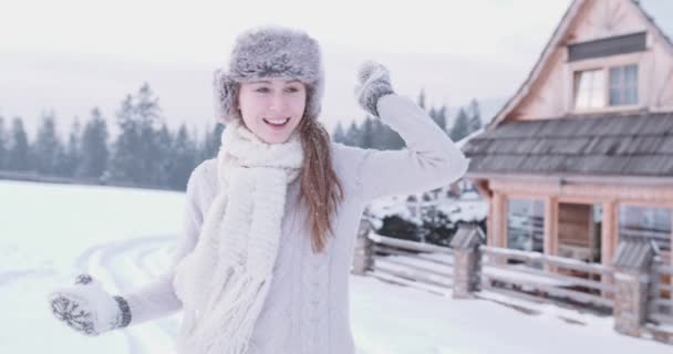 Joven mujer adulta lanzando nieve — Vídeos de Stock