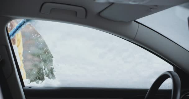 Vrouw schoonmaken van sneeuw en ijs uit haar auto — Stockvideo