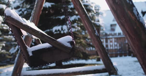 Columpio de madera con columpio de nieve — Vídeo de stock