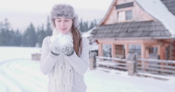 Mujer soplando nieve de sus manos — Vídeos de Stock