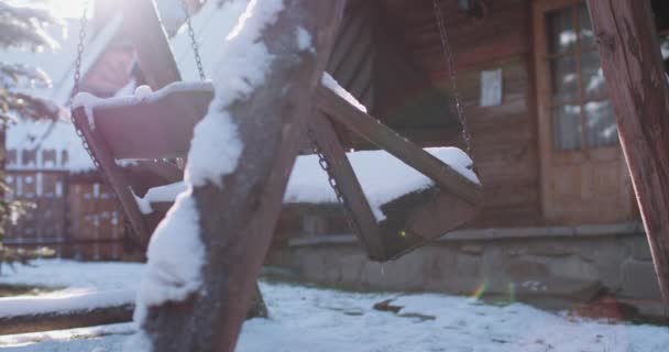Деревянные качели с раскачиванием снега — стоковое видео