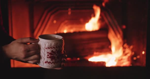 Kvinna med kopp varm te brasan — Stockvideo