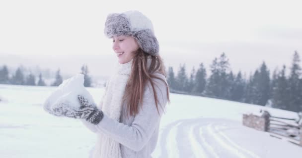 Joven mujer adulta lanzando nieve — Vídeos de Stock