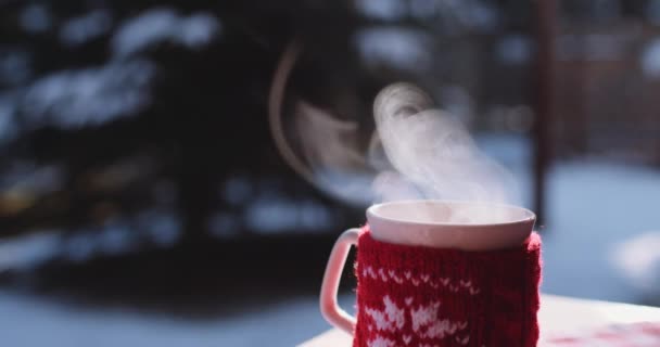 Чашка горячего напитка зимой — стоковое видео