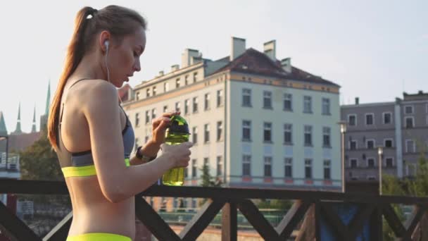 Runner femme boire de l'eau et courir — Video