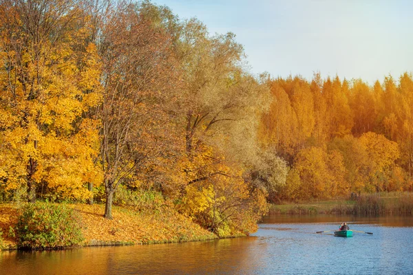 Parque de outono junto ao lago com barco . — Fotografia de Stock