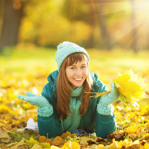 Frau liegt im Herbstpark auf dem Boden. — Stockfoto