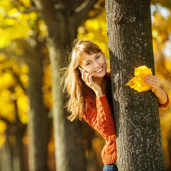 Mujer hablando por teléfono móvil en el parque de otoño — Foto de Stock