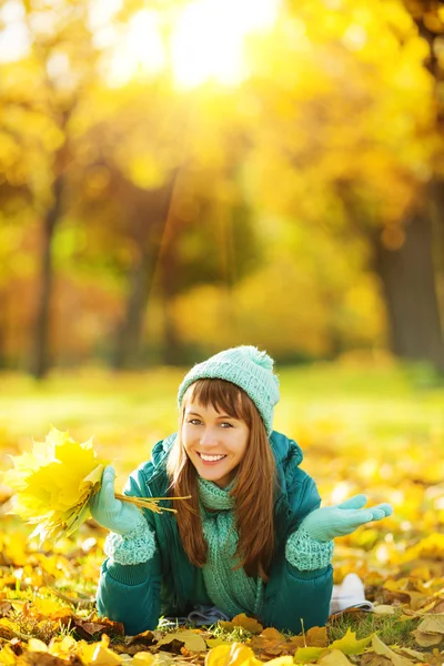 Frau liegt im Herbstpark auf dem Boden. — Stockfoto