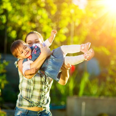 Anne ve kızı güneşli bahçede eğleniyor