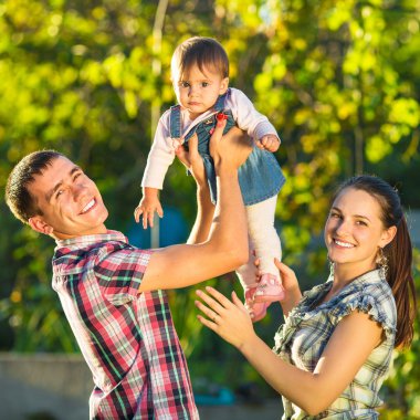 Mutlu genç aile dışarıda eğleniyor.