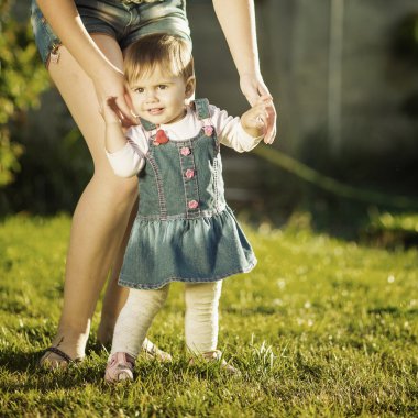 Kız bebek ilk adımlarını anneler yardımıyla yapıyor